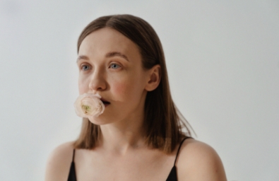 woman with a white rose in her mouth