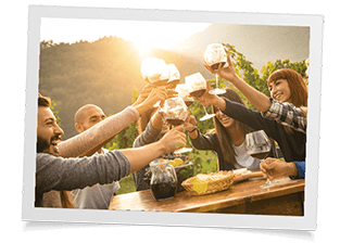 photograph of happy people cheering with wine glasses